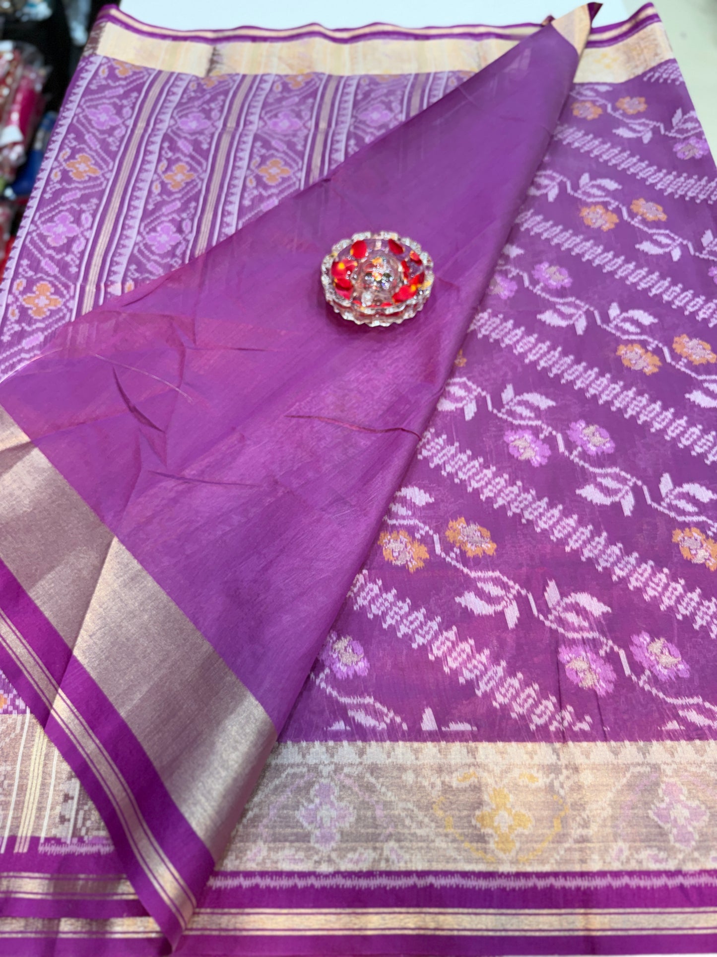 Women’s ikat style woven saree with contrast border and tassel pallu